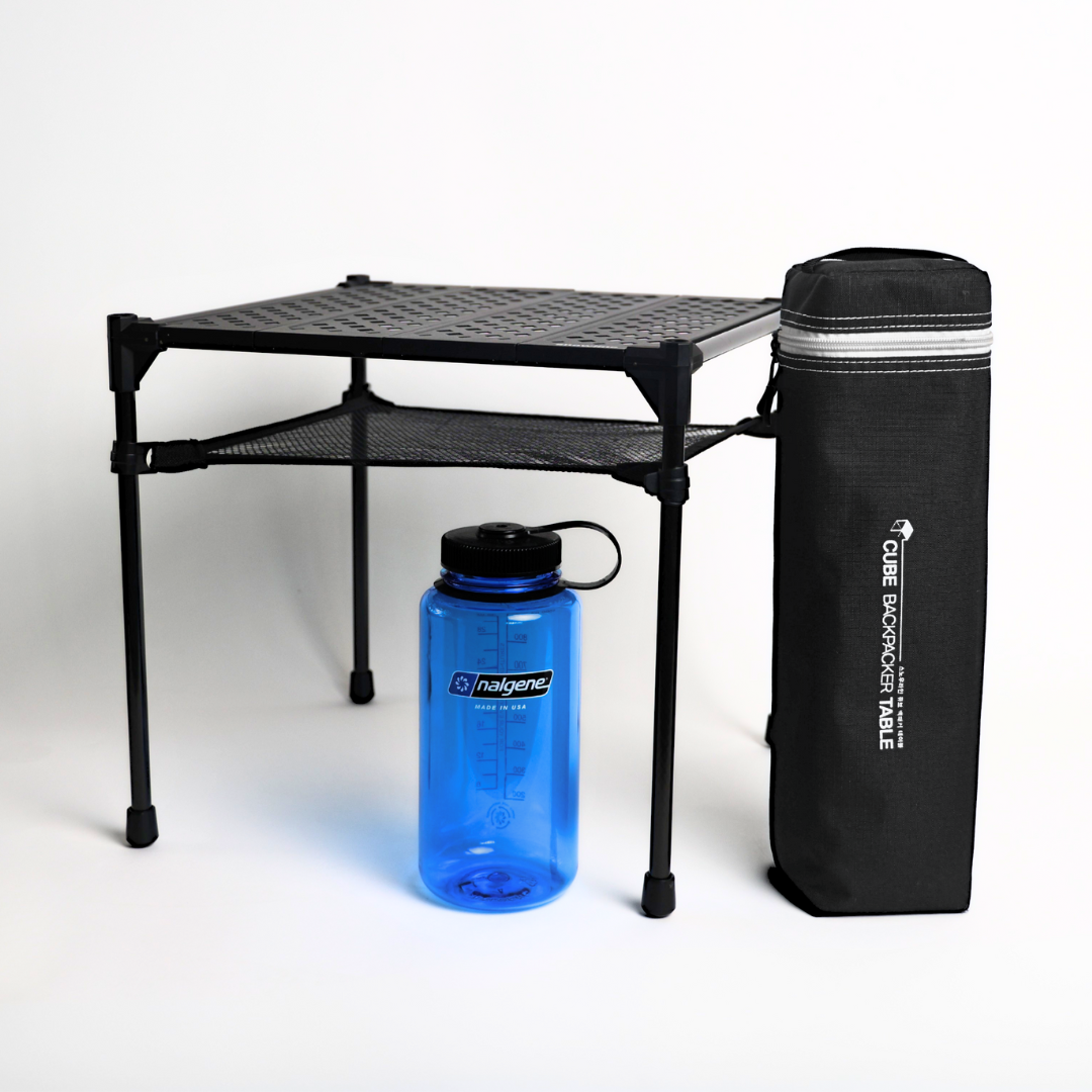 Ein Bild zum Veranschaulichen der Größen des Backpacker Table in aufgebautem Zustand und verpacktem Zustand mit einer Nalgene Flasche.